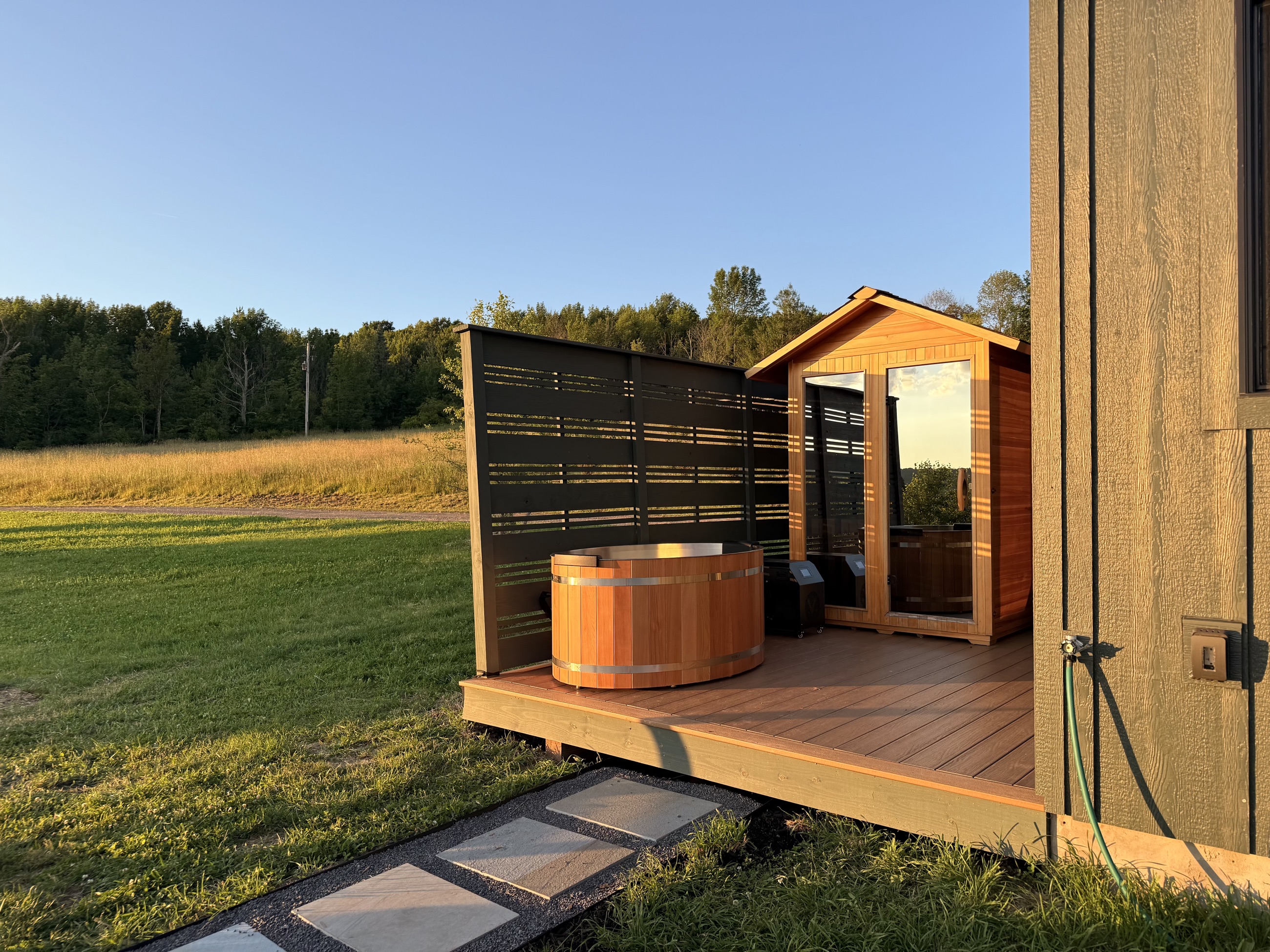 The sauna and cold plunge on the back deck in golden light